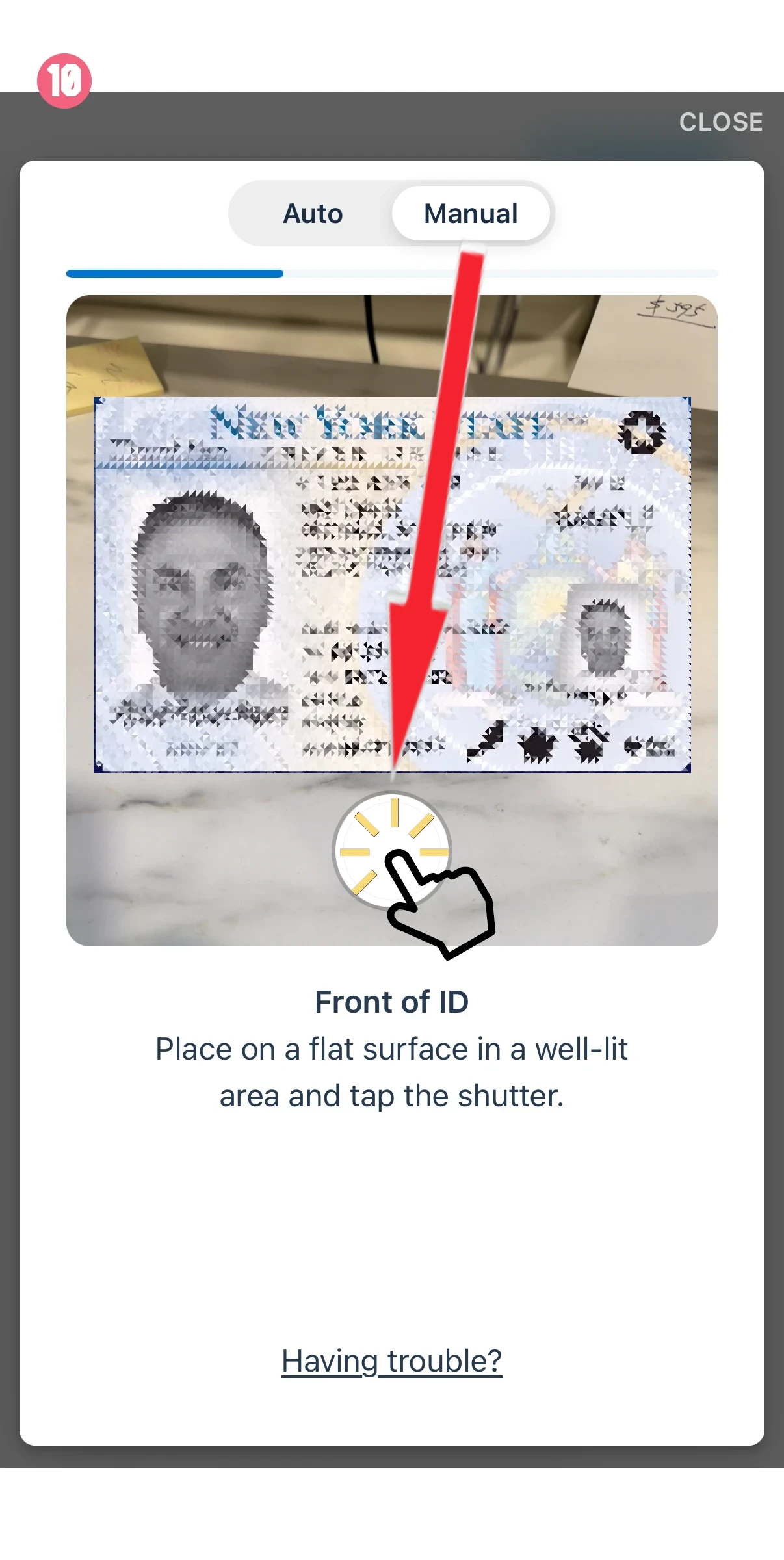 Tutorial screen showing an ID card laid face up on a flat surface, with a hand-toke shutter icon and the text 'Front of ID' - tap to capture.
