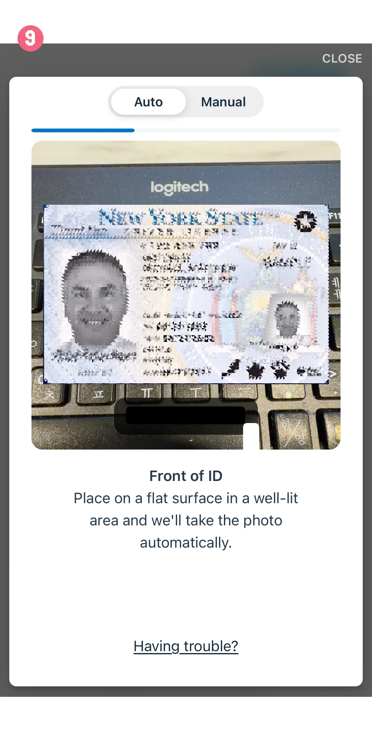 Screen shows an ID capture step: a blurred ID front on a keyboard, with Auto/Manual tabs and the 'Front of ID' instruction to place it on a flat surface.